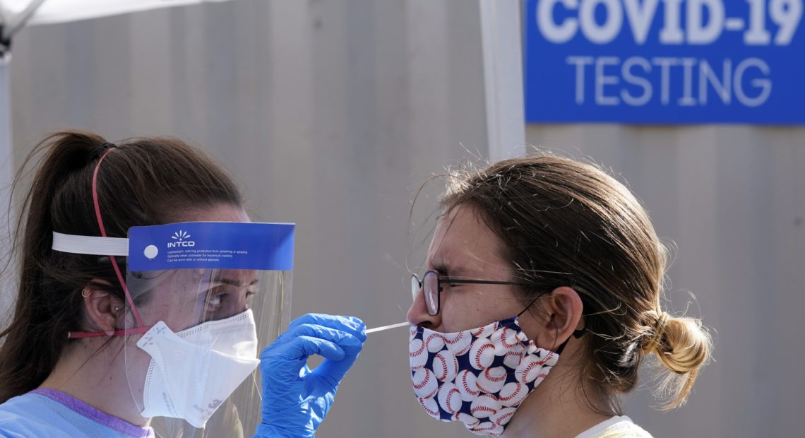 People stand in line for free COVID-19 testing at Bellevue Hospital in New York earlier this month. The daily number of new coronavirus cases reported in the U.S. has remained stubbornly high. CREDIT: Bryan R. Smith/AFP via Getty Images