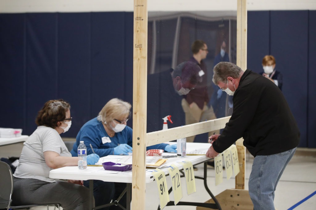 A man checks to cast his ballot in Kenosha, Wis., on April 7. A new study suggests that in-person voting in that Wisconsin primary did not produce a surge of new coronavirus cases. CREDIT: Kamil Krzaczynski /AFP via Getty Images