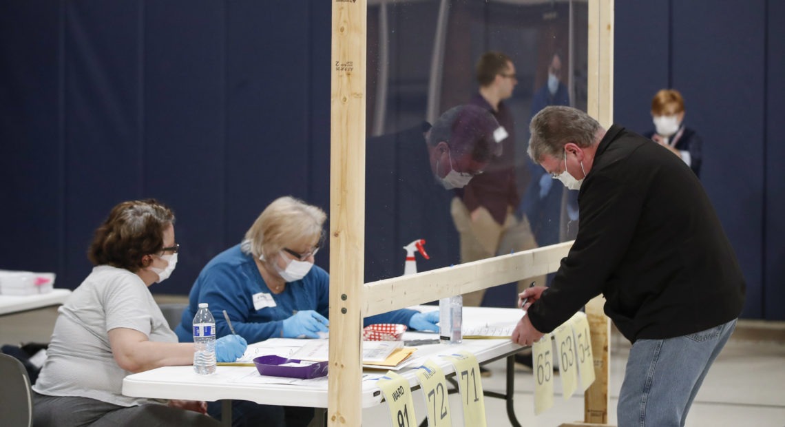 A man checks to cast his ballot in Kenosha, Wis., on April 7. A new study suggests that in-person voting in that Wisconsin primary did not produce a surge of new coronavirus cases. CREDIT: Kamil Krzaczynski /AFP via Getty Images