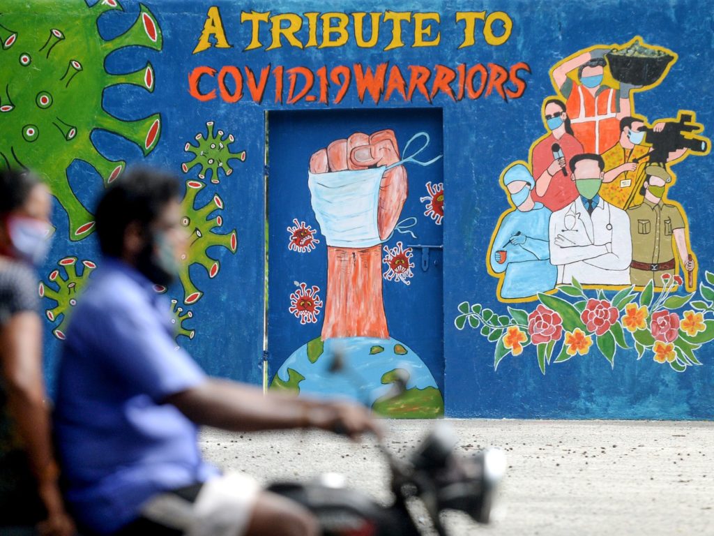 A mural in Chennai, India, celebrates workers on the front lines against the coronavirus pandemic. The global case count crossed the 20 million threshold on Monday, with the U.S., Brazil and India in the lead. Arun Sankar/AFP via Getty Images