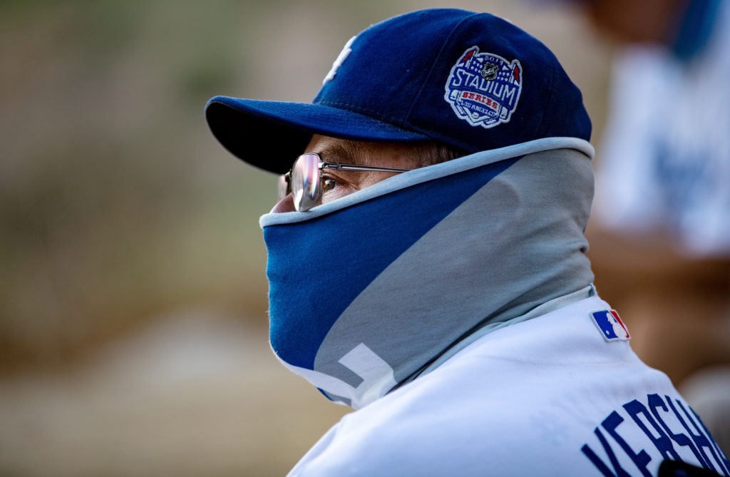 A fan wears a neck gaiter as he watches the Los Angeles Dodgers play at home against the San Francisco Giants last week. Gina Ferazzi/Los Angeles Times via Getty Images