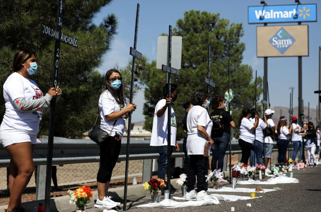 Mourners hold 23 crosses Monday in front of a Walmart honoring those killed in the 2019 attack in El Paso, Texas. CREDIT: Mario Tama/Getty Images