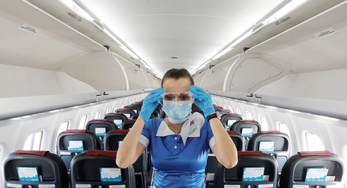 A flight attendant adjusts protective glasses. There has been little documentation about COVID-19 transmission on planes. CREDIT: Valentyn Ogirenko/Reuters