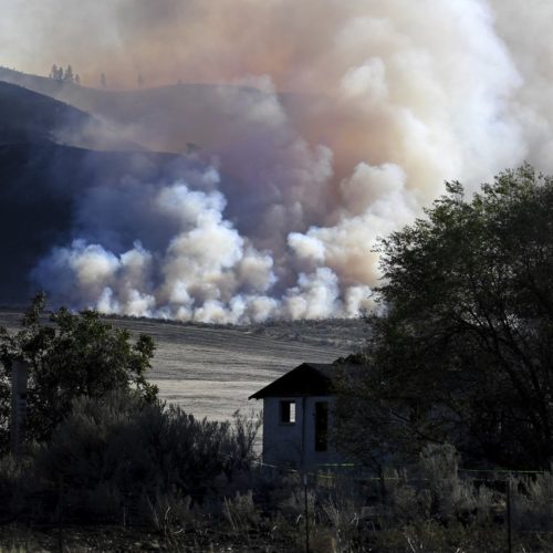 Late afternoon light catches smoke from the Cold Springs Fire near a structure that appeared to be empty long before the fire, Monday, Sept. 7, 2020, near Omak, Washington. CREDIT: Tyler Tjomsland/The Spokesman-Review via AP