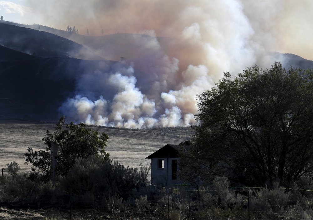 Late afternoon light catches smoke from the Cold Springs Fire near a structure that appeared to be empty long before the fire, Monday, Sept. 7, 2020, near Omak, Washington. CREDIT: Tyler Tjomsland/The Spokesman-Review via AP