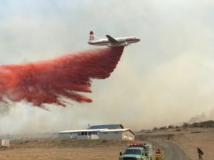 A plane drops fire retardant near a home Sept. 2, 2020, during the Evans Canyon Fire burning in Yakima and Kittitas counties. Courtesy of Tony Miller