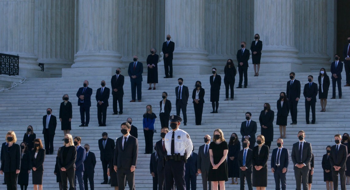 Former law clerks for Justice Ruth Bader Ginsburg stand on the steps of the U.S. Supreme Court in Washington, D.C., as they await the arrival of the casket on Wednesday. CREDIT: Claire Harbage/NPR
