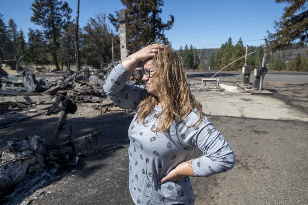 Hollie Jordan surveys her father's service station that was destroyed by a wildfire on Tuesday, Sept. 8, 2020, in Malden, Wash. 