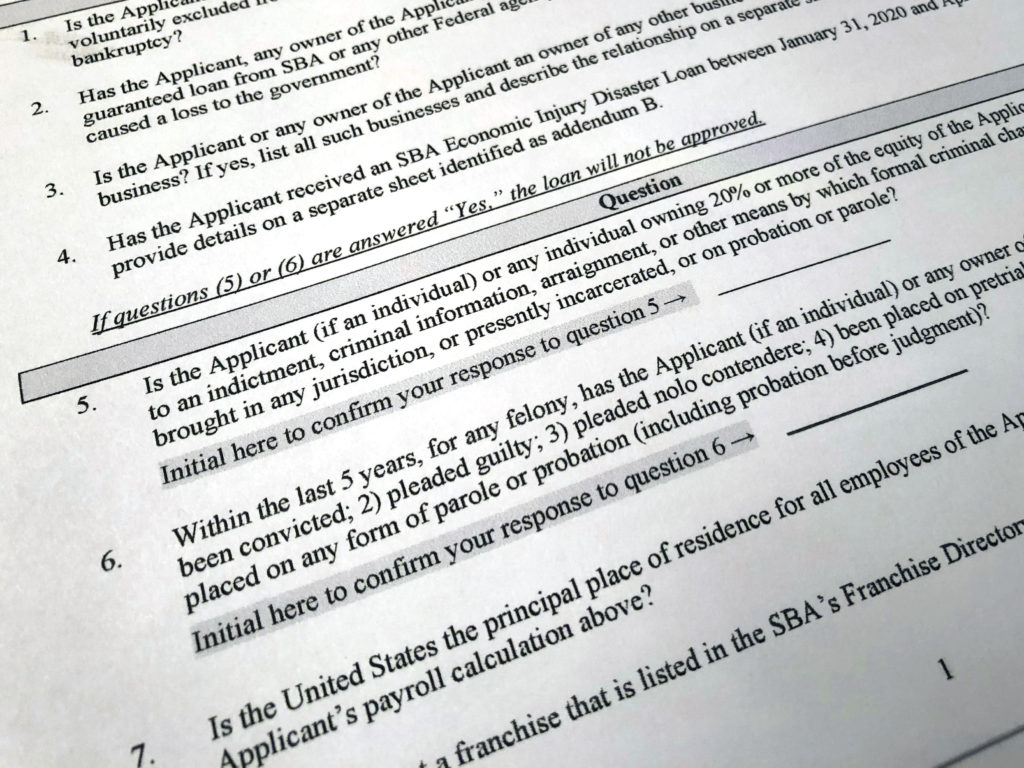 The Justice Department has accused 57 people of defrauding the Paycheck Protection Program. A portion of the program's application is shown here. CREDIT: Wayne Partlow/AP