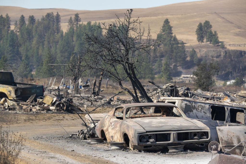 Vehicles were destroyed by a wildfire in Malden, Wash., on Monday, Sept. 7, 2020. Large parts of the West Coast are under warnings for elevated fire weather threats Thursday, but there may be relief if fire-driving winds decrease as expected. CREDIT: Jed Conklin/AP