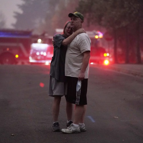 A couple embrace Thursday, Sept. 10, 2020, while touring an area devastated by the Almeda Fire in Phoenix, Ore. John Locher/AP