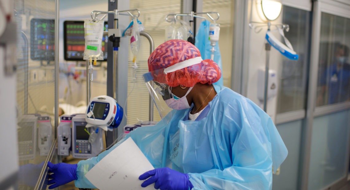 Niticia Mpanga, a registered respiratory therapist, checks on an ICU patient at Oakbend Medical Center in Richmond, Texas. The mortality rates from COVID-19 in ICUs have been decreasing worldwide, doctors say, at least partly because of recent advances in treatment. Mark Felix/AFP via Getty Images