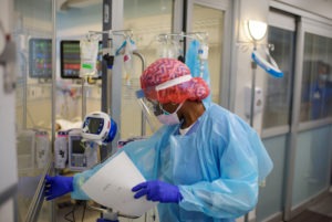 Niticia Mpanga, a registered respiratory therapist, checks on an ICU patient at Oakbend Medical Center in Richmond, Texas. The mortality rates from COVID-19 in ICUs have been decreasing worldwide, doctors say, at least partly because of recent advances in treatment. Mark Felix/AFP via Getty Images