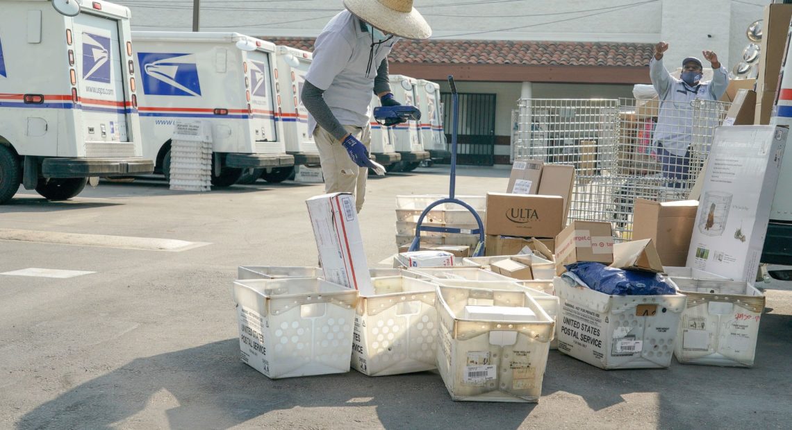 Postal workers sort, load and deliver mail at a U.S. Postal Service location last month in Los Angeles. CREDIT: Kyle Grillot/AFP via Getty Images