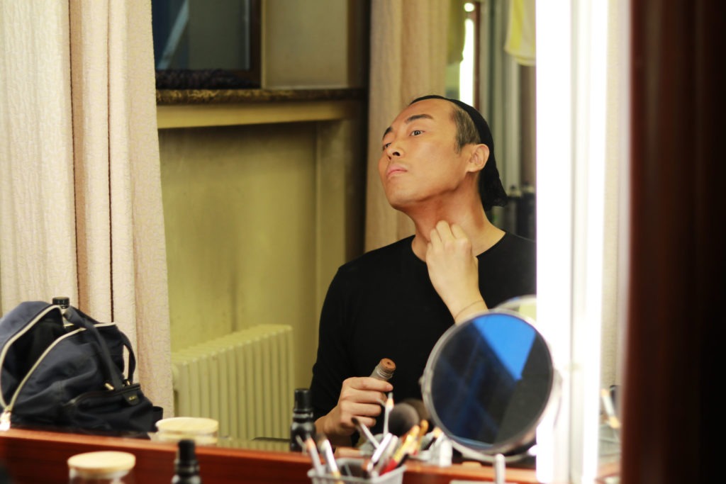 Actor Jin Han, who plays Walter Lee Younger, powders on dark stage make up on opening night of the production on Sept. 1. CREDIT: Amy Cheng/NPR