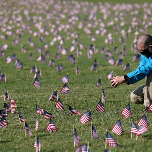 The U.S. hit a tragic milestone Tuesday, recording more than 200,000 coronavirus deaths. Here, Chris Duncan, whose mother, Constance, 75, died from COVID-19 on her birthday, visits a COVID Memorial Project installation of 20,000 American flags on the National Mall. The flags are on the grounds of the Washington Monument, facing the White House. Win McNamee/Getty Images