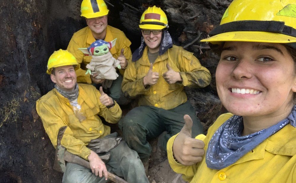 Lucas Galloway, from left, Jaebyn Drake, Rhett Schieder and Audrey Wilcox pose for a selfie with Baby Yoda on Sept. 20, 2020, while fighting the Holiday Farm Fire in Blue River, Oregon. In early September, a 5-year-old Oregon boy named Carver and his grandmother delivered a toy version of “The Mandalorian” character to a donation center for firefighters. Courtesy of Audrey Wilcox via AP