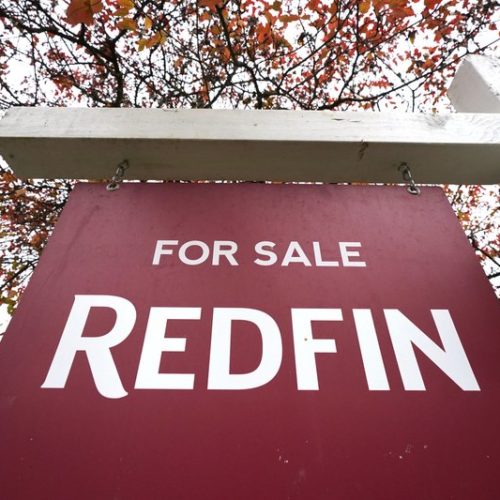 A Redfin "for sale" sign stands in front of a house Oct. 28, 2020, in Seattle. Several fair housing organizations accused Redfin of systematic racial discrimination in a lawsuit, saying the online real estate broker offers fewer services to homebuyers and sellers in minority communities, a type of "digital redlining" that has depressed home values and exacerbated historic injustice in the housing market. CREDIT: Elaine Thompson/AP