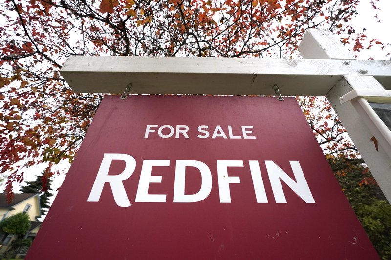 A Redfin "for sale" sign stands in front of a house Oct. 28, 2020, in Seattle. Several fair housing organizations accused Redfin of systematic racial discrimination in a lawsuit, saying the online real estate broker offers fewer services to homebuyers and sellers in minority communities, a type of "digital redlining" that has depressed home values and exacerbated historic injustice in the housing market. CREDIT: Elaine Thompson/AP