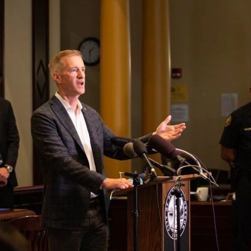 Mayor Ted Wheeler stands between Police Chief Chuck Lovell, right, and Multnomah County District Attorney Mike Schmidt at an Aug. 30 press conference. CREDIT: Bradley W. Parks / OPB