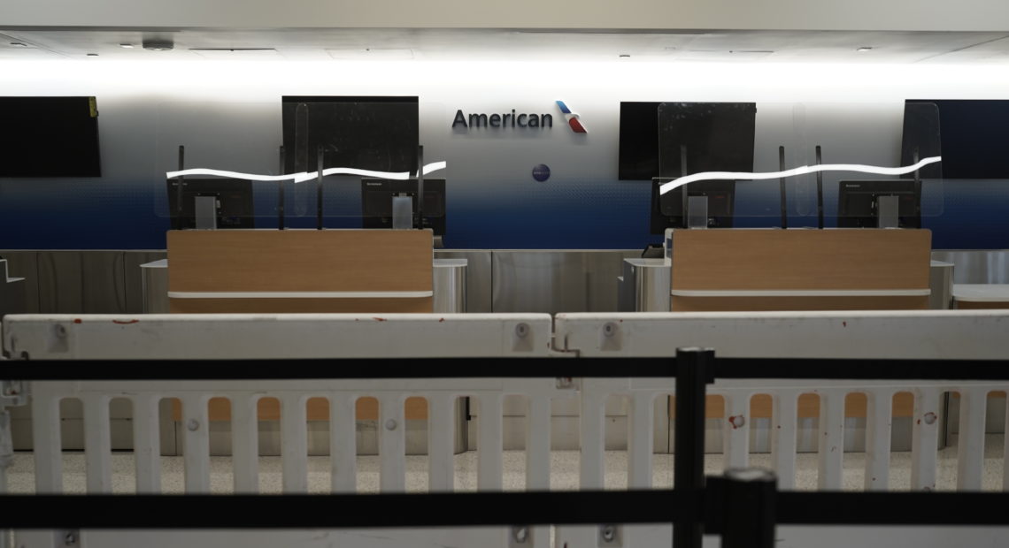 American Airlines check-in counters sit closed last month behind plastic barriers at Los Angeles International Airport. CREDIT: Bing Guan/Bloomberg via Getty Images
