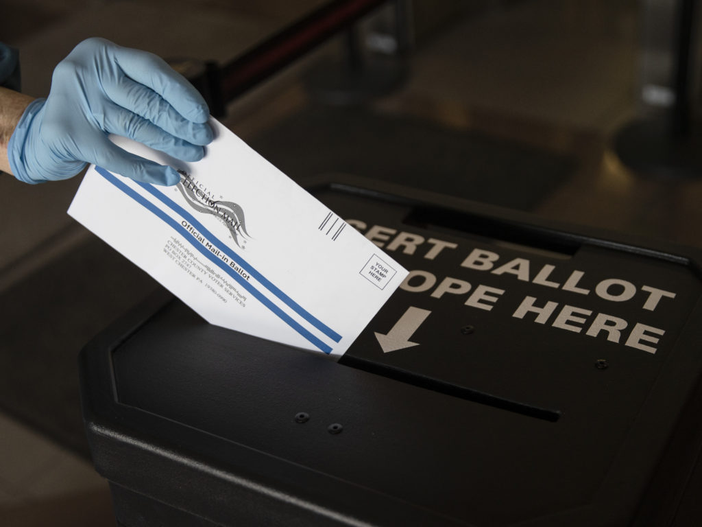 In this May 2020 photo, a voter casts her mail-in ballot at in a drop box in West Chester, Pa., prior to the primary election. On Saturday a federal judge blocked a Trump campaign lawsuit to limit the use of drop boxes in the state. CREDIT: Matt Rourke/AP