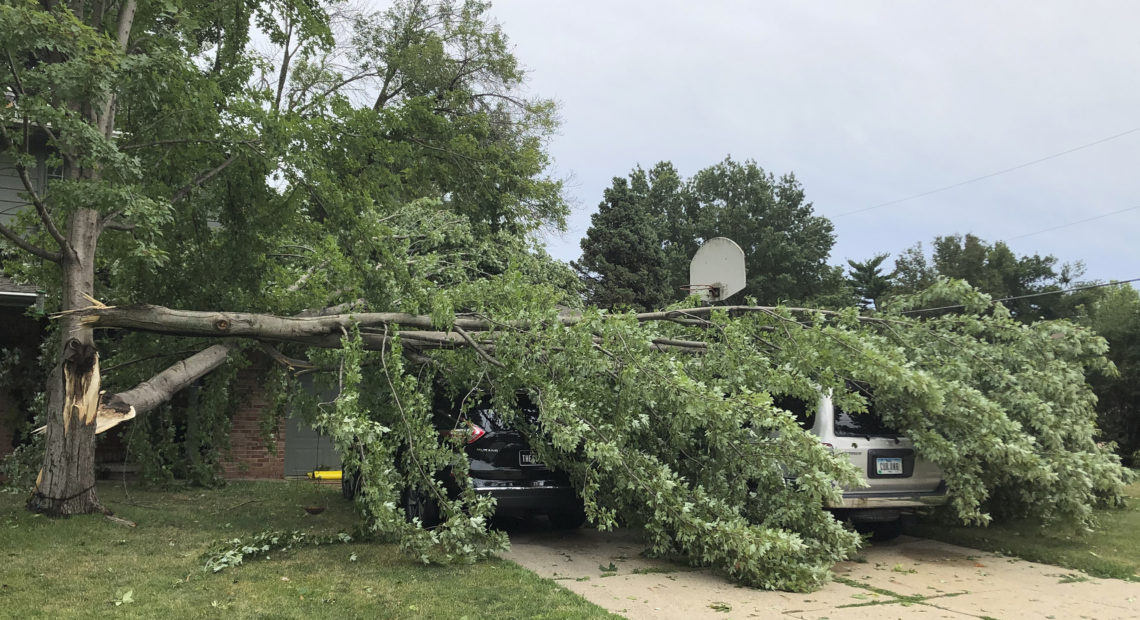 A tree fell across vehicles at a home in West Des Moines after a severe thunderstorm moved across Iowa on Aug. 10. It was the costliest storm system in modern U.S. history. CREDIT: David Pitt/AP