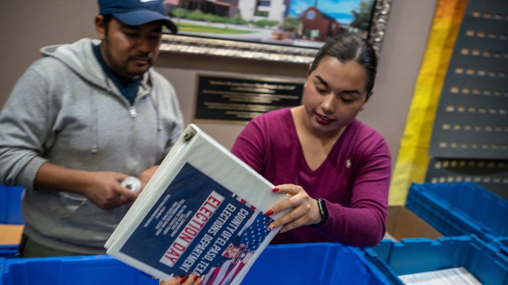 Jonathan Lucero and Valeria Gutierrez prepare to receive ballots at the El Paso County Courthouse during the presidential primary in March. Paul Ratje/AFP via Getty Images