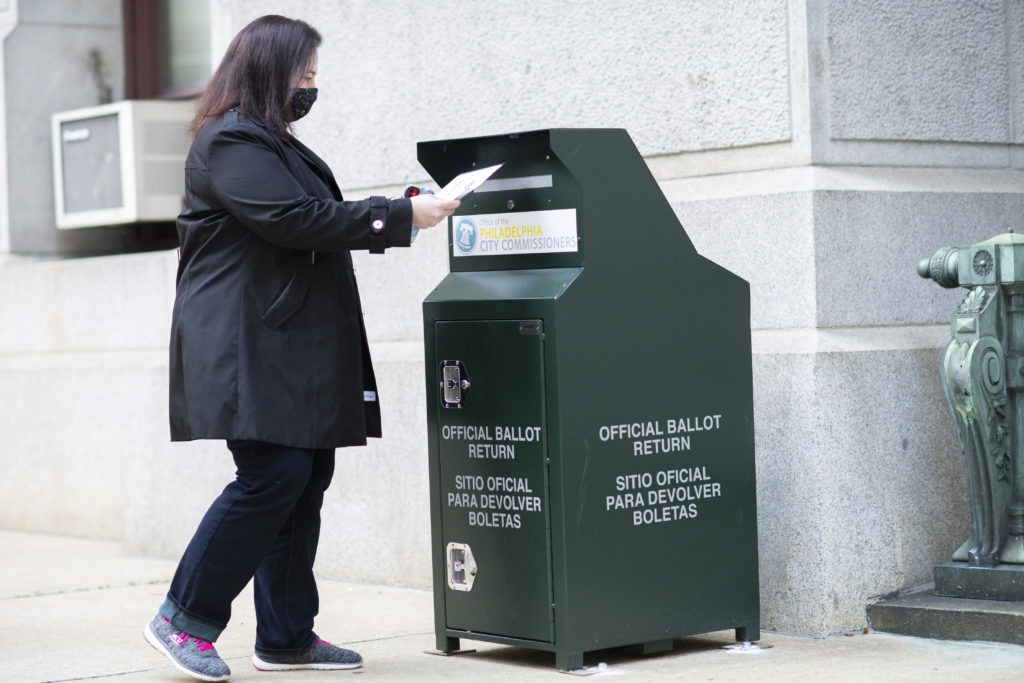 A voter casts her early-voting ballot at a drop box outside City Hall in Philadelphia on Oct. 17. Mark Makela/Getty Images