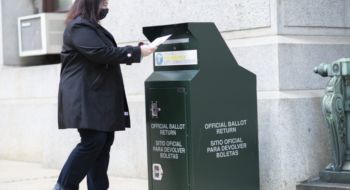 A voter casts her early-voting ballot at a drop box outside City Hall in Philadelphia on Oct. 17. Mark Makela/Getty Images