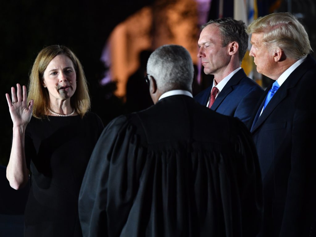 President Trump watches as Supreme Court Justice Clarence Thomas administers the constitutional oath to Amy Coney Barrett during a ceremony at the White House Monday evening. CREDIT: Nicholas Kamm/AFP via Getty Images