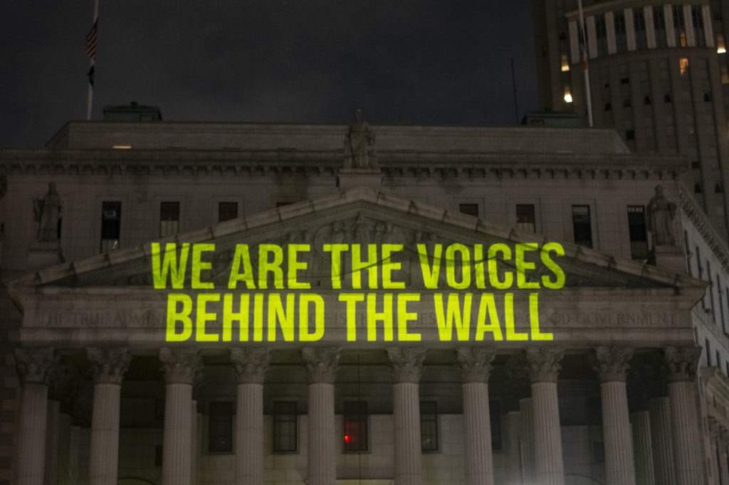 "The Writing On The Wall" art installation projects writings by incarcerated people onto the sides of buildings, such as The New York State Supreme Court Building, above. Chemistry Creative