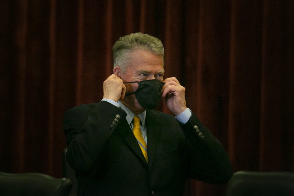 File photo. Idaho Gov. Brad Little puts on a face mask before a public meeting earlier this year. So far he has resisted calls for a statewide mandate. On Sunday, Nov. 8, the governor of Utah, Idaho's southern neighbor, imposed a mask mandate. CREDIT: Idaho Education News