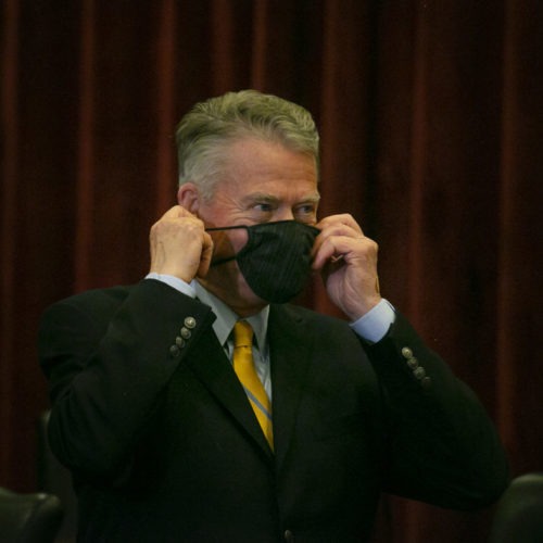 File photo. Idaho Gov. Brad Little puts on a face mask before a public meeting earlier this year. So far he has resisted calls for a statewide mandate. On Sunday, Nov. 8, the governor of Utah, Idaho's southern neighbor, imposed a mask mandate. CREDIT: Idaho Education News