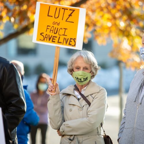 Carolyn Holmes holds a sign in favor of Dr. Anthony Fauci and Health Officer Bob Lutz during a protest against the Spokane Board of Health's ousting of Lutz, held on Nov. 1, 2020 outside the Spokane Regional Health District office. News of the controversial situation broke on Friday, and Lutz has since said that he will not resign and has acquired an attorney in order to keep his employment with the SRHD in the middle of the COVID-19 pandemic.