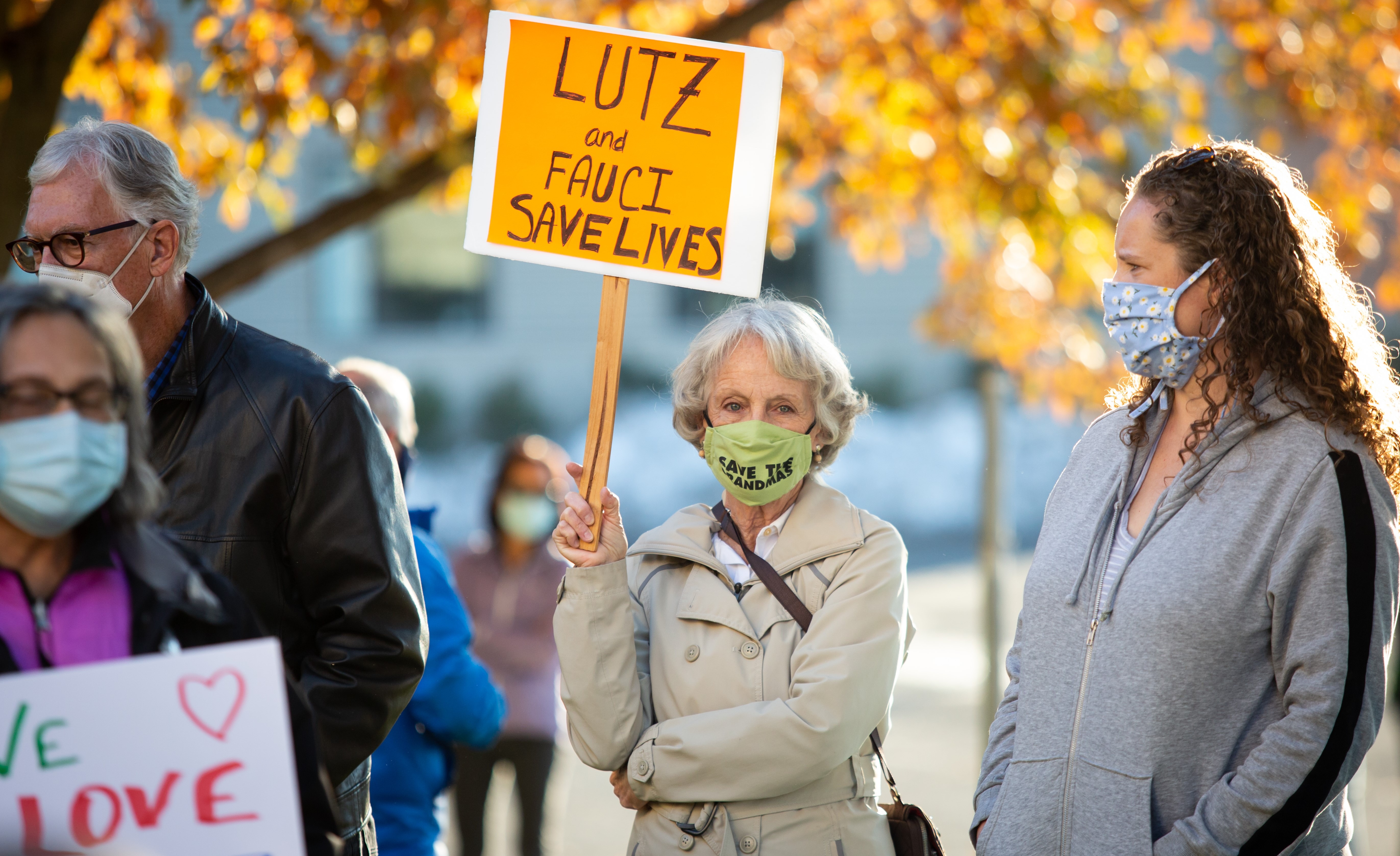 Carolyn Holmes holds a sign in favor of Dr. Anthony Fauci and Health Officer Bob Lutz during a protest against the Spokane Board of Health's ousting of Lutz, held on Nov. 1, 2020 outside the Spokane Regional Health District office. News of the controversial situation broke on Friday, and Lutz has since said that he will not resign and has acquired an attorney in order to keep his employment with the SRHD in the middle of the COVID-19 pandemic.