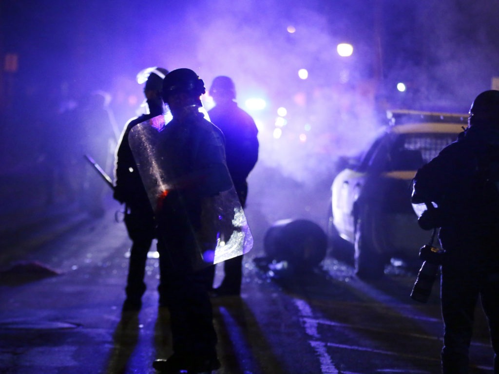 Police officers in Ferguson, Mo., during a protest in 2014. Advocates want the Justice Department to step up its oversight of law enforcement in the incoming administration. Charlie Riedel/AP