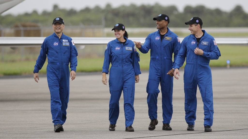 From left, astronaut Soichi Noguchi of Japan and NASA astronauts Shannon Walker, Victor Glover and Michael Hopkins walk after arriving at Kennedy Space Center in Cape Canaveral, Fla. The four astronauts will fly on the SpaceX Crew-1 mission to the International Space Station scheduled for launch on Saturday. CREDIT: Terry Renna/AP