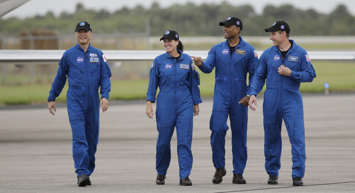 From left, astronaut Soichi Noguchi of Japan and NASA astronauts Shannon Walker, Victor Glover and Michael Hopkins walk after arriving at Kennedy Space Center in Cape Canaveral, Fla. The four astronauts will fly on the SpaceX Crew-1 mission to the International Space Station scheduled for launch on Saturday. CREDIT: Terry Renna/AP