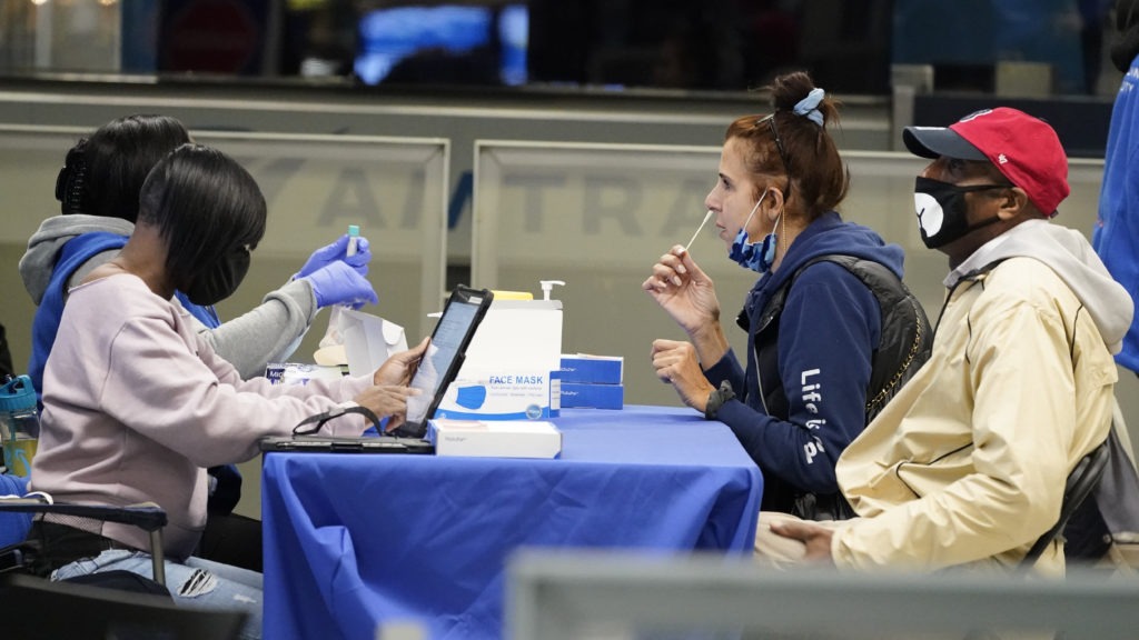 Travelers self-test for the coronavirus at a mobile testing site at New York City's Penn Station in the days leading up to Thanksgiving. The U.S. is currently seeing record hospitalizations for COVID-19, and health experts fear more surges are on their way. CREDIT: Mary Altaffer/AP