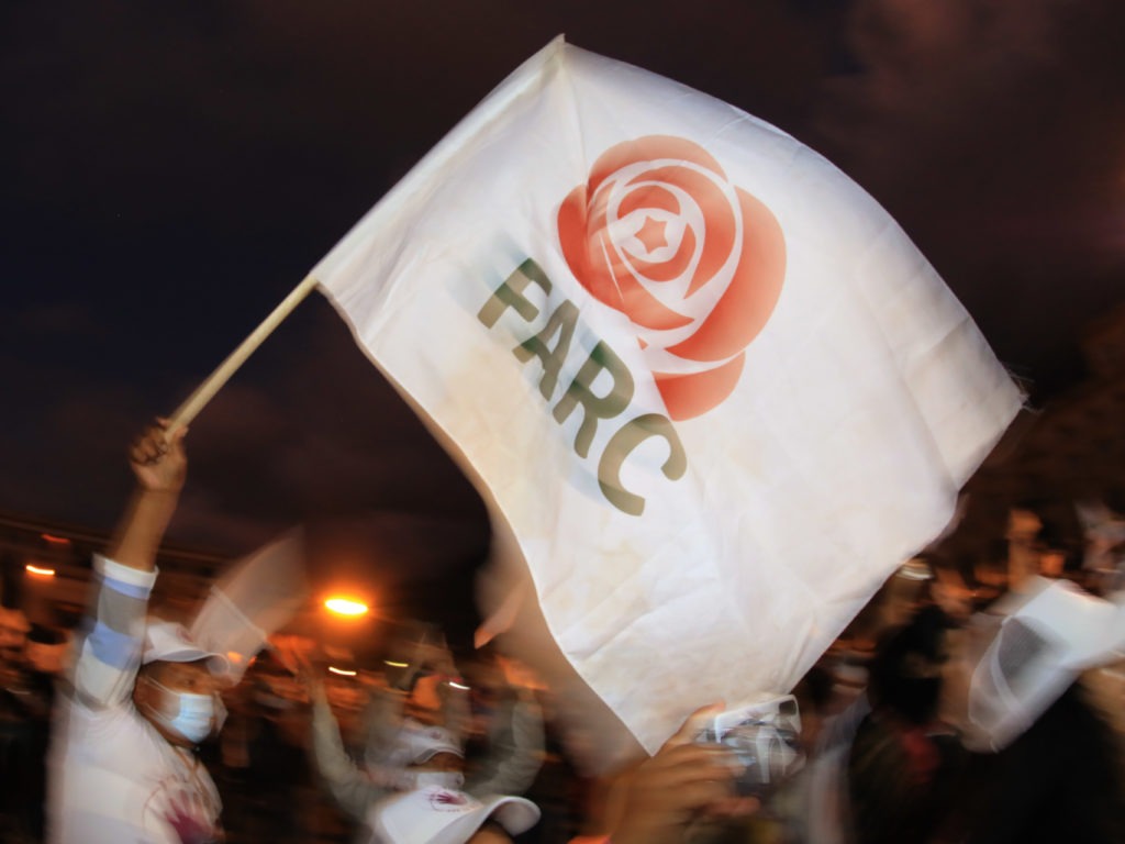 A former FARC guerrilla member waves a FARC political party flag during a demonstration in Bogota on Nov. 2. A federal court overturned an asylum decision Wednesday, holding that FARC death threats counted as persecution.× CREDIT: Daniel Munoz/AFP via Getty Images