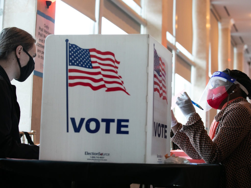 A poll worker helps K. Maki (left) fill out a provisional ballot at Park Tavern polling station on Tuesday in Atlanta, Ga. After a record-breaking early voting turnout, Americans head to the polls on the last day to cast their vote. CREDIT: Jessica McGowan/Getty Images