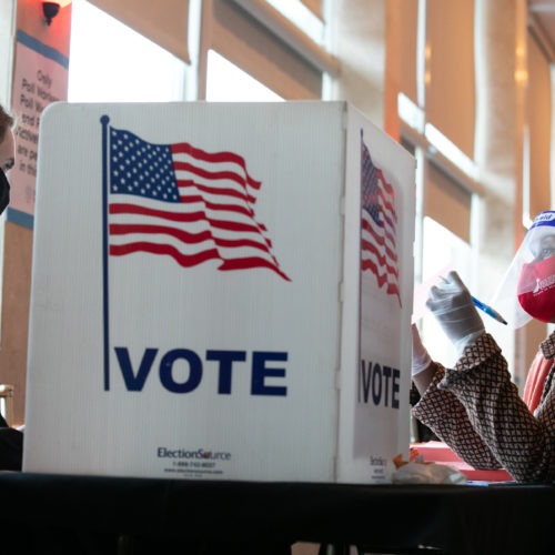 A poll worker helps K. Maki (left) fill out a provisional ballot at Park Tavern polling station on Tuesday in Atlanta, Ga. After a record-breaking early voting turnout, Americans head to the polls on the last day to cast their vote. CREDIT: Jessica McGowan/Getty Images