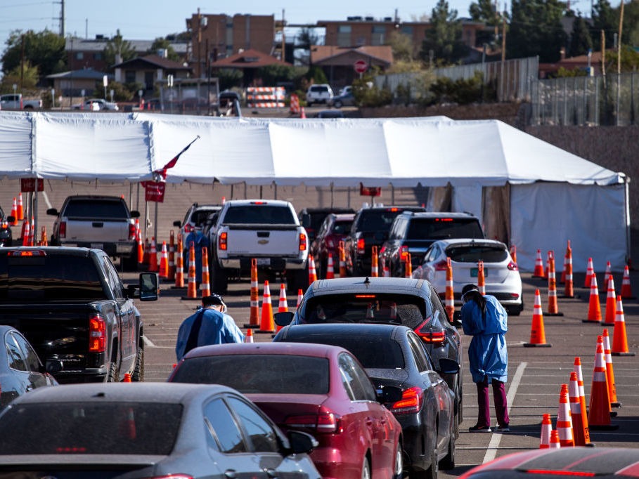 Medical workers wearing personal protective equipment register people in vehicles at a drive-through coronavirus testing site Monday in El Paso, Texas. Joel Angel Juarez/Bloomberg via Getty Images