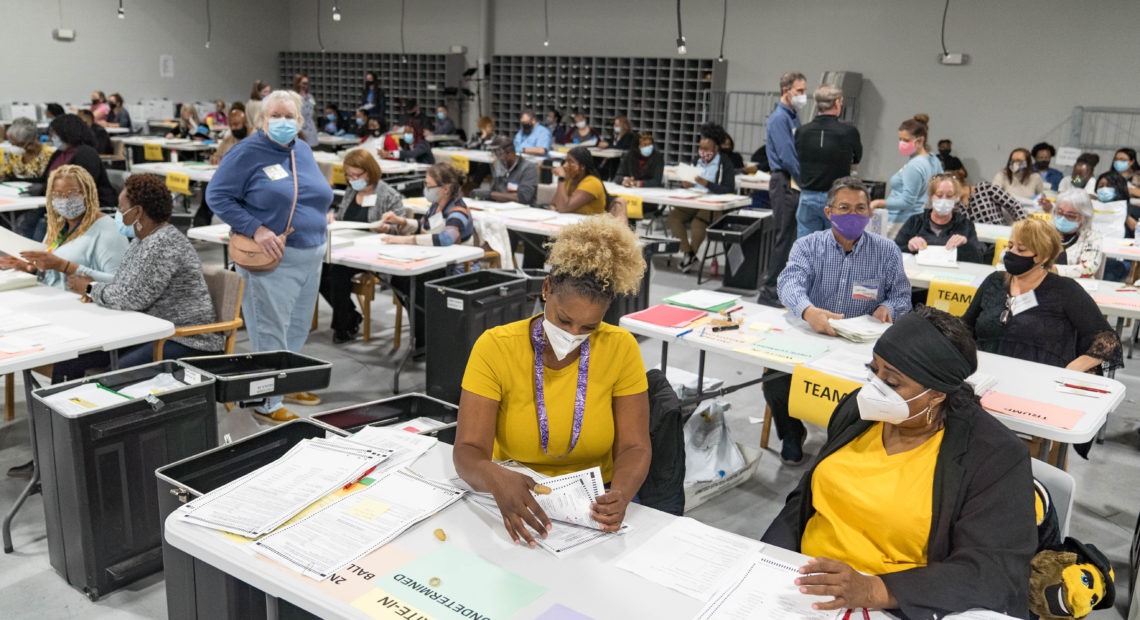 Gwinnett County election workers handle ballots Monday in Lawrenceville, Ga., as part of the state's recount for the 2020 presidential election. CREDIT: Megan Varner/Getty Images