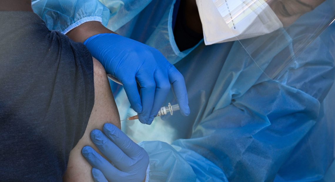 A flu vaccine is administered at a walk-up COVID-19 testing site, in San Fernando, Calif. Emergency use authorization is expected soon for vaccines for COVID-19. Robyn Beck/AFP via Getty Images