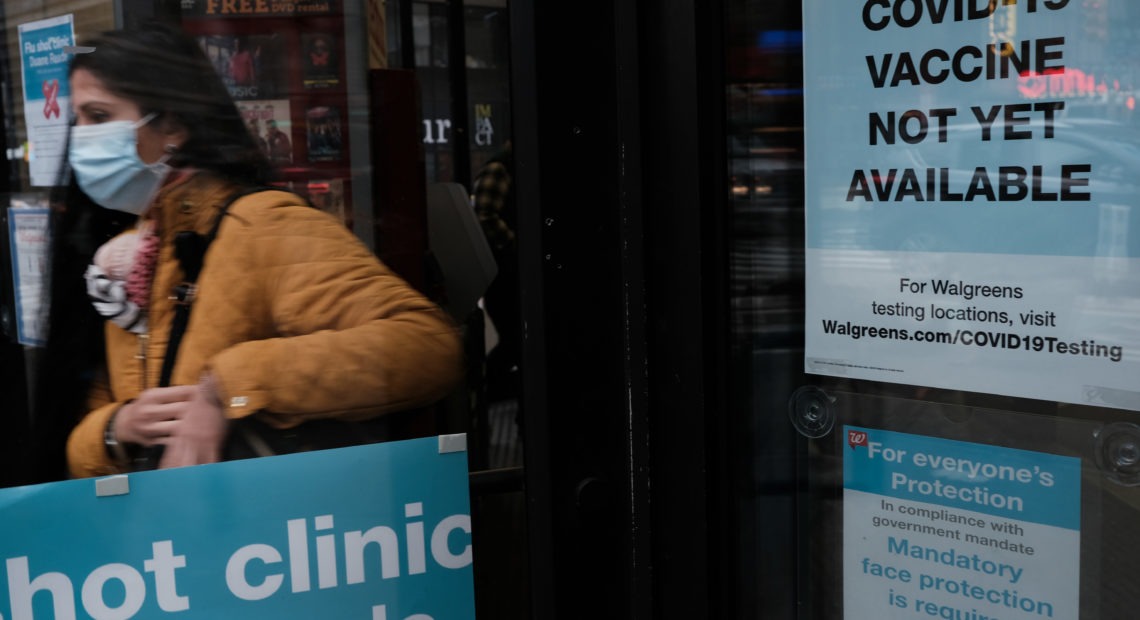 No vaccine available sign - person walking into Walgreens