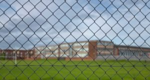 Photo of an empty school looking through a fence