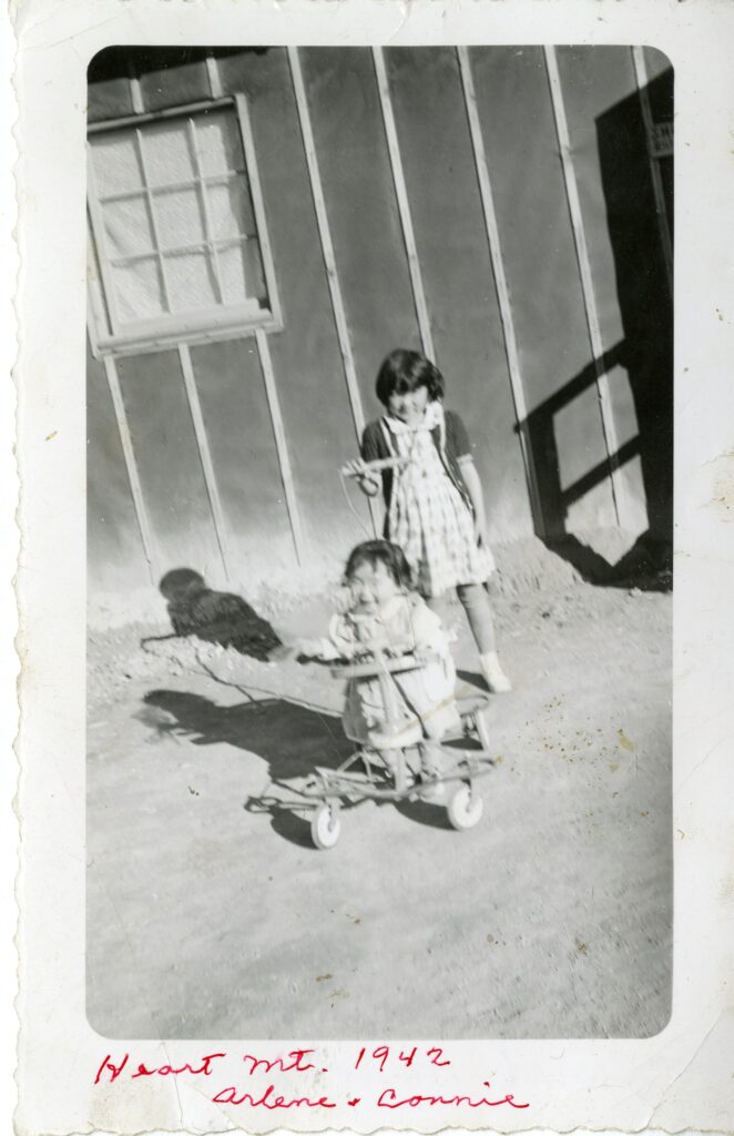 Two children of Japanese descent playing at the Heart Mountain Internment Camp in Wyoming.