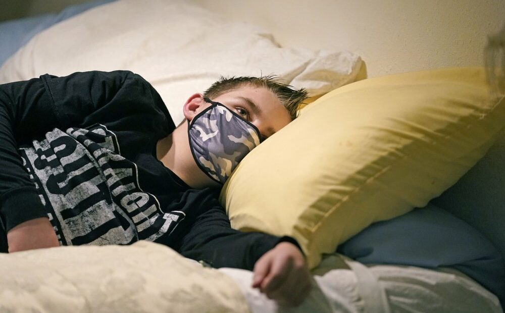 Cooper Wuthrich rests as he lays on a bed at the truck stop his family partly owns Tuesday, Dec. 15, 2020, in Montpelier, Idaho. Shortly after Thanksgiving, Wuthrich, 12, became one of hundreds of children in the U.S. diagnosed with a rare COVID-19 complication that landed him in an emergency room three hours away from his tiny hometown in a secluded Idaho valley. The boy's parents say he nearly died and their terrifying experience shows why people should wear masks in a conservative state where pushback can be fierce. CREDIT: Rick Bowmer